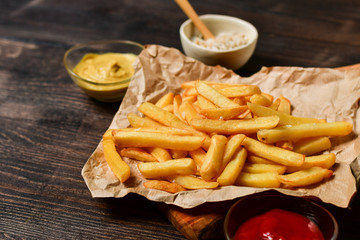 French fries with ketchup, mustard and salt. fast food lunch on a wooden table. Business lunch...