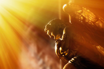 God’s gold angel in the sunlight. Antique statue.
