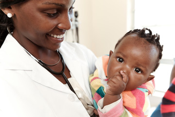 Closeup of an African female doctor holding an infant