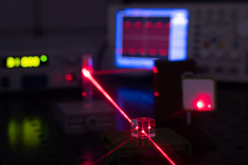 Obraz premium Experiment in optic lab with laser device. Red laser on optical table in physics laboratory