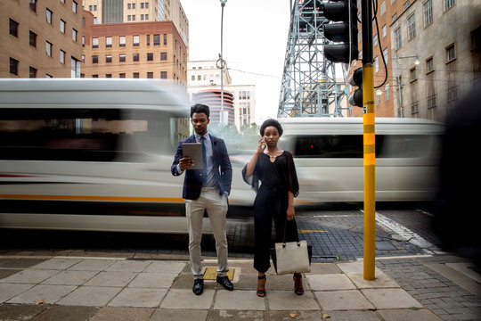 Businessman and businesswoman standing beside traffic light