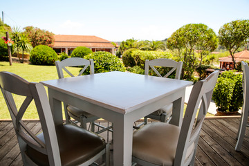 White wooden table and blurreed background of summer garden 