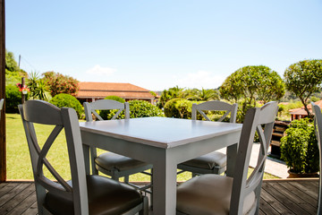 White wooden table and blurreed background of summer garden 