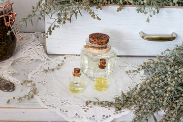 Bottles of essential oil with blooming wormwood