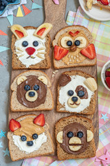 Fototapeta na wymiar Funny animal faces toasts with spreads, butters, banana, strawberry and blueberry