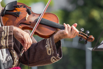 Hands of violinist and violin during an open air concert_