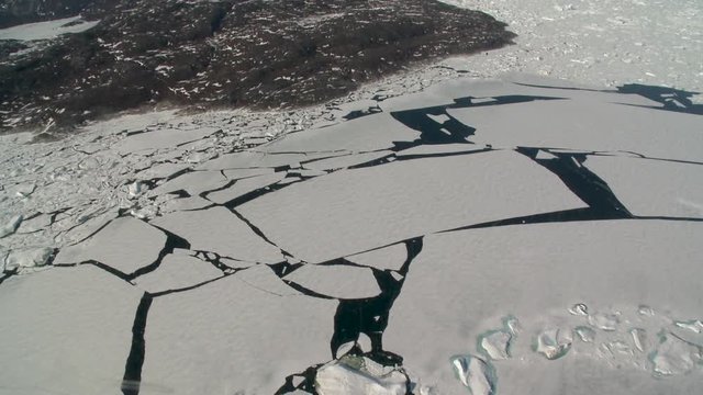 Point of view, helicopter flies over cracked ice