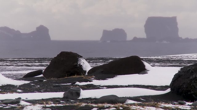 Snowy rock formations on Iceland beach, wide