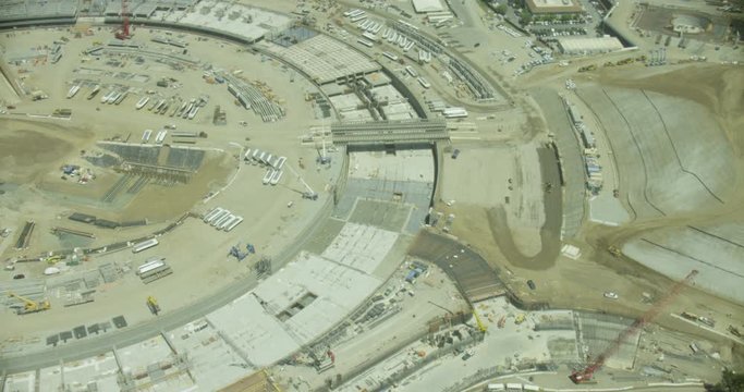 Helicopter aerial panning over round construction site, birds eye view, day