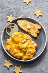 Kids funny breakfast with scrambled eggs, cheese and tortilla space rocket