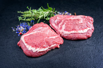 Traditional German raw beef cheeks offered as closeup on a black board with copy space