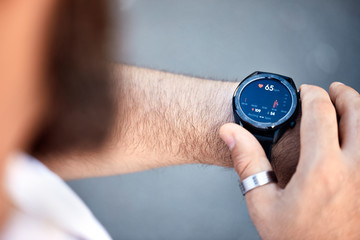 Close-up of man checking medical data on smartwatch