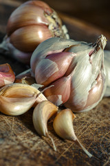 Organic garlic,Closeup garlic on wooden texture on for cooking on dark background, concept healthy lifestyle.Fresh peeled garlics and bulbs.