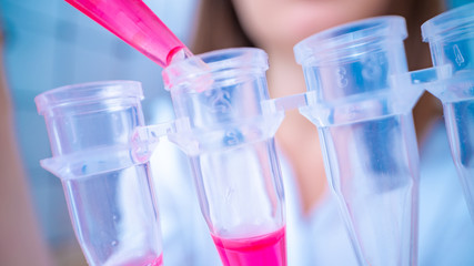 Young woman fill PCR microtubes with dispenser