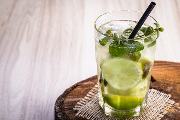 Mojito cocktail at the bar. Mojito cocktail over rustic wood. Cold Mojito, rum, lime and mint tourist drink.