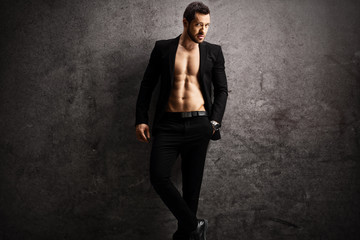 Handsome man in a black suit posing shirtless