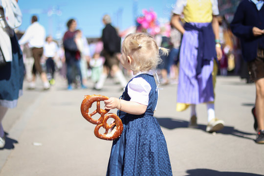Kind auf dem Oktoberfest mit Brezel in der Hand