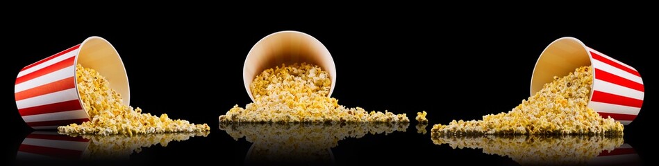 Set of paper striped buckets with scattered popcorn isolated on black background