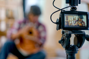 The monitor of camera show Asian old craftsman present his wood product and look like he sell it online.  Concept of using natural material to produce hand-made woodworking after retire.