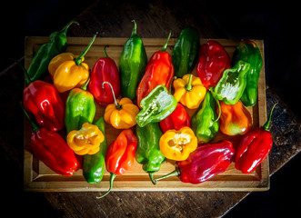 Colorful chili peppers on a cutting board, the overhead shot of this species that is sweet in taste, very common in South America.