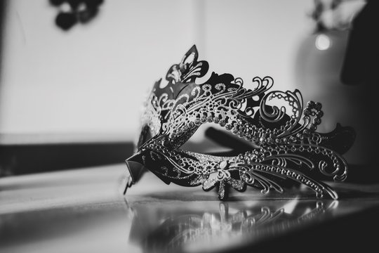 A black and white portrait of a mysterious venetian mask lit by a window. A great way to hide your identity on a masked ball, carnival or halloween party.