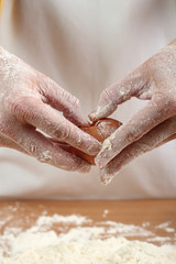 A baker cracking an egg into a pile of flour. Making Pastry Dough for Hungarian Cake. Series.