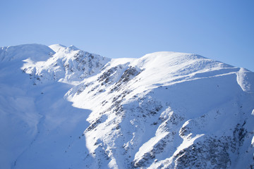 Fototapeta na wymiar Mountain peaks under heavy snow fall