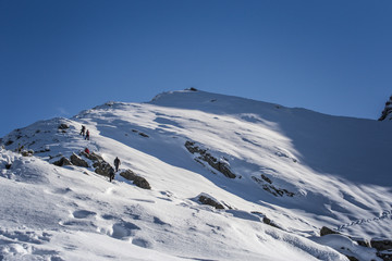 Hikers climbing mountain peak in a sunny day
