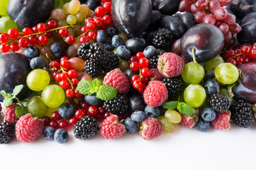 Ripe blackberries, blueberries, raspberries, red currants, plums and grapes. Mix berries and fruits. Top view. Background berries and fruits. Black-blue and red berries and fruits.