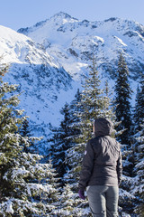 Fototapeta na wymiar Girl hiker in front of snowy mountain
