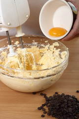 Adding Eggs into Batter. Making Chocolate Chip Cookies. Series.