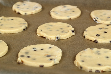 Raw cookies baking on baking parchment. Making Chocolate Chip Cookies. Series.