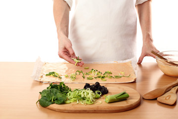 Spreading sliced leek on dough. Making Pizza with Leek and Spinach. Series.