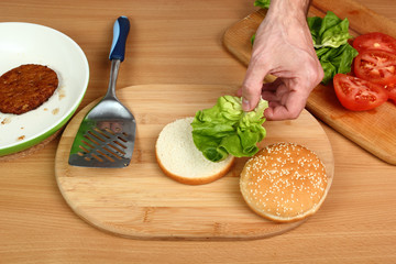 Put Lettuce on Bread Roll. Making Hamburger. Series.