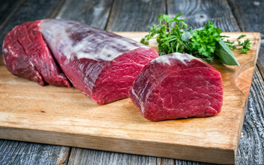 Dry aged beef fillet steak natural offered as closeup on a wooden cutting board