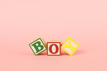 Colored cubes with letters Boy on a pink background