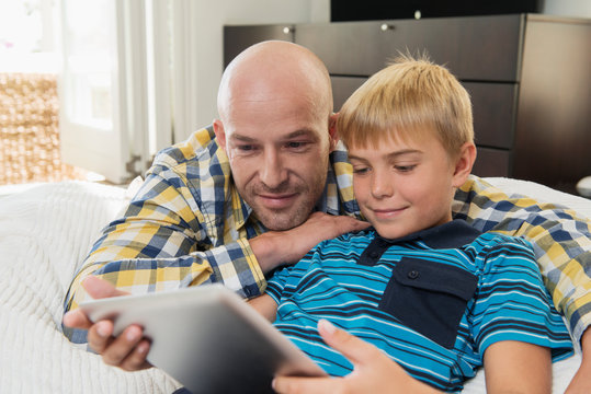 Father with son (10-12) using digital tablet