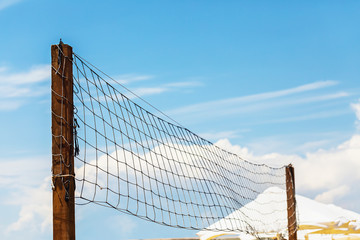 Volleyball net on the beach against the blue sky