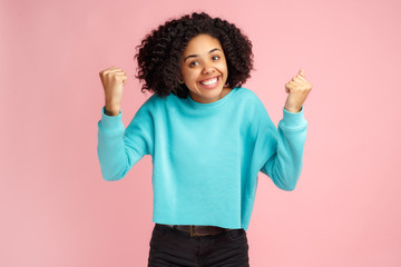 Photo of excited screaming african american young woman standing over pink background.