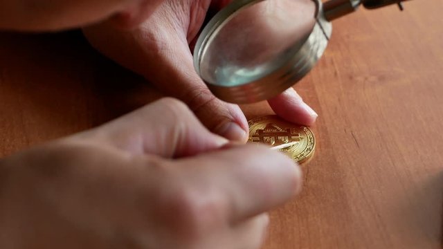 criminal man counterfeit golden bitcoin. making virtual money in real world. crypto currency mining concept close-up macro 4k video footage
