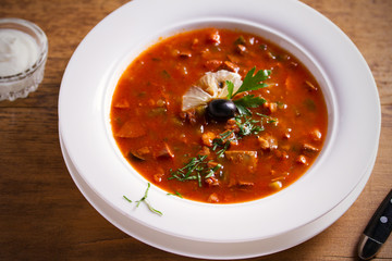 Solyanka - thick, spicy and sour Russian soup, made of beef, ham, sausages, chicken breast cucumber pickles and tomatoes