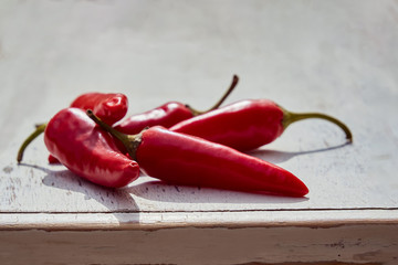 Fresh red chili peppers on an old vintage wooden table, copy space, soft selective focus