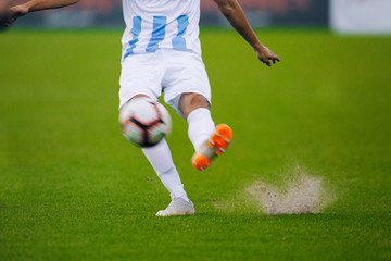 Close up of a soccer striker dynamic kicks the ball