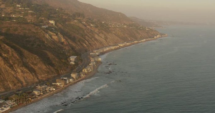 Helicopter aerial of highway and coastline homes, sundown