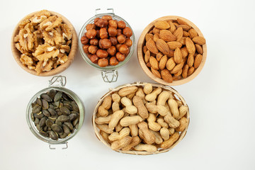 Orzechy pestki dyni w miskach na białym tle