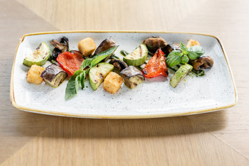 Grilled vegetables with feta cheese. Serving on a plate on a table. Barbecue restaurant menu, a series of photos of different dishes
