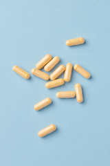 Coenzyme Q10 capsules. Dietary supplements. Bright paper background. Top view. Copy space. 
