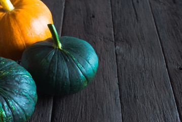 Orange pumpkin and green squash on a wooden table. Harvest season
