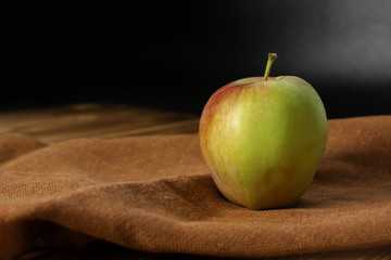 Green and red fresh organic apple on wooden table