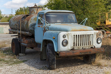 Rusty abandoned soviet truck gas-53 with a tank  